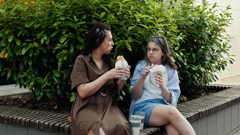 madre e hija almorzando al aire libre