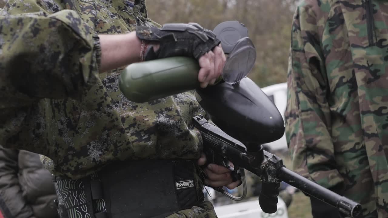 un hombre carga armas de paintball