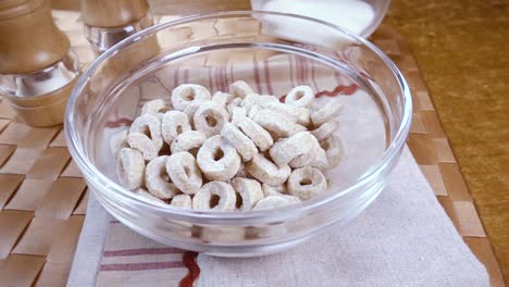 copos de avena crujientes en un tazón para un delicioso desayuno matutino con leche. cámara lenta con toma de seguimiento de rotación.