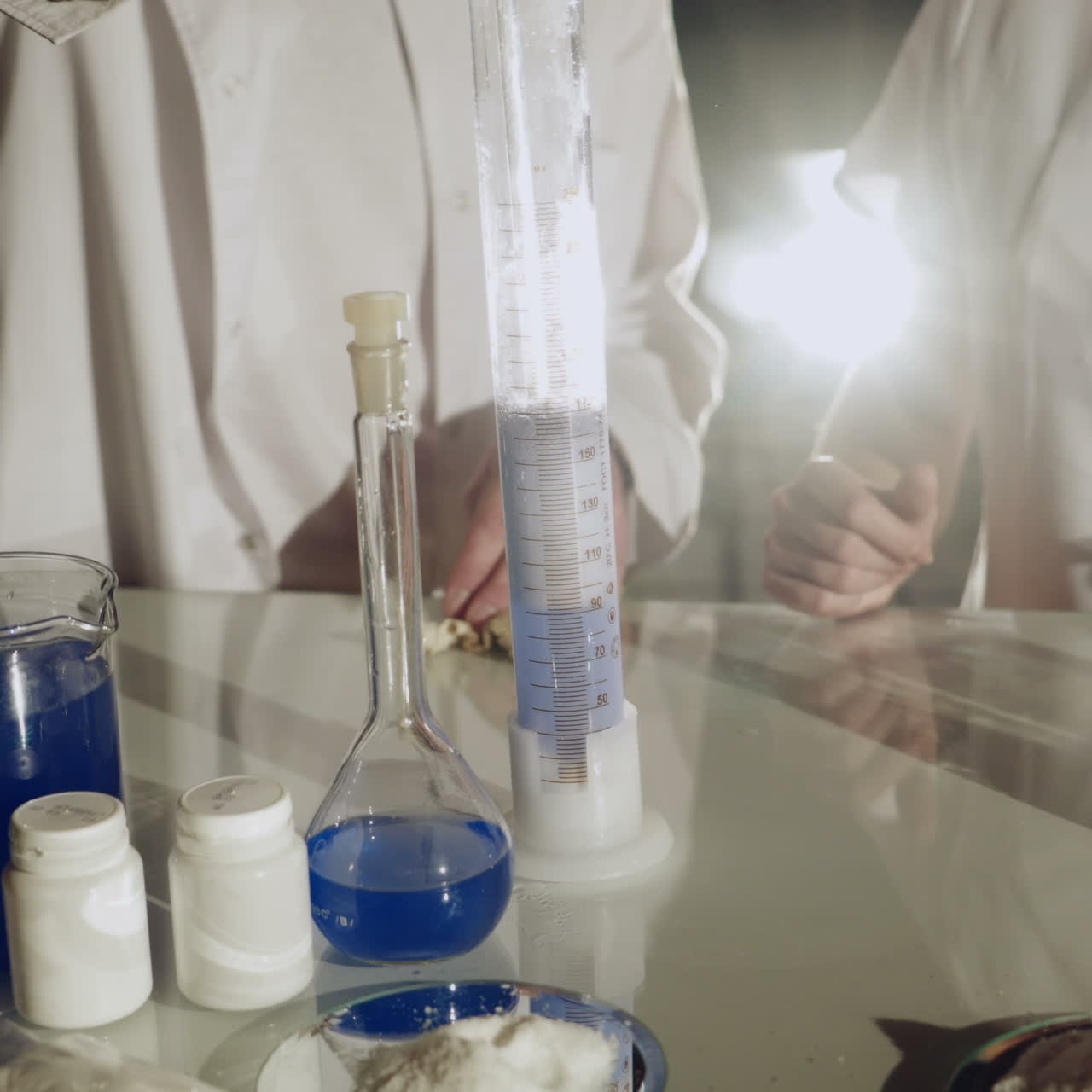 Scientist working with chemical reaction in chemistry lab. Chemical reaction in glass flask. Lab worker doing chemical experiment in laboratory Square video