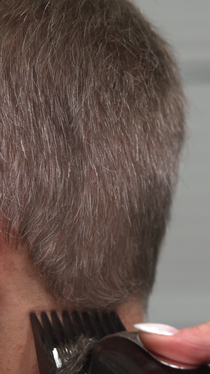 Primo piano di un tagliacapelli che rifinisce i capelli corti sulla nuca