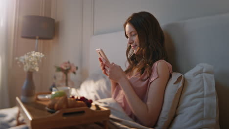 cheerful woman typing smartphone in morning. serene dreamy girl enjoy breakfast