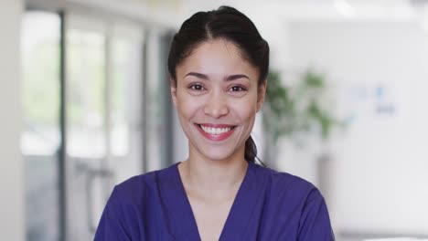 Video-portrait-of-happy-biracial-female-medical-worker-smiling-in-hospital