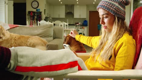 woman stroking her dog while using mobile phone on sofa 4k