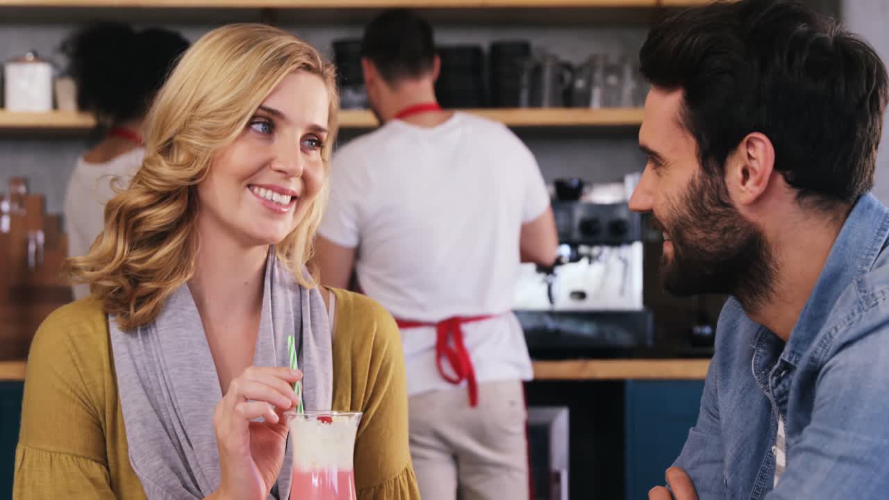 커플이 커피 한 잔과 밀크 이크를 마시면서 상호 작용합니다.