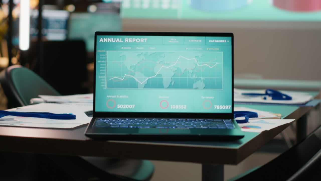 Close up of laptop running data insights in empty dark office late at night