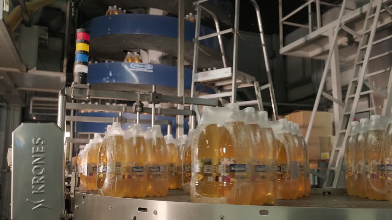 máquina moderna de ataduras y transporte para la línea de envasado en la planta de bebidas