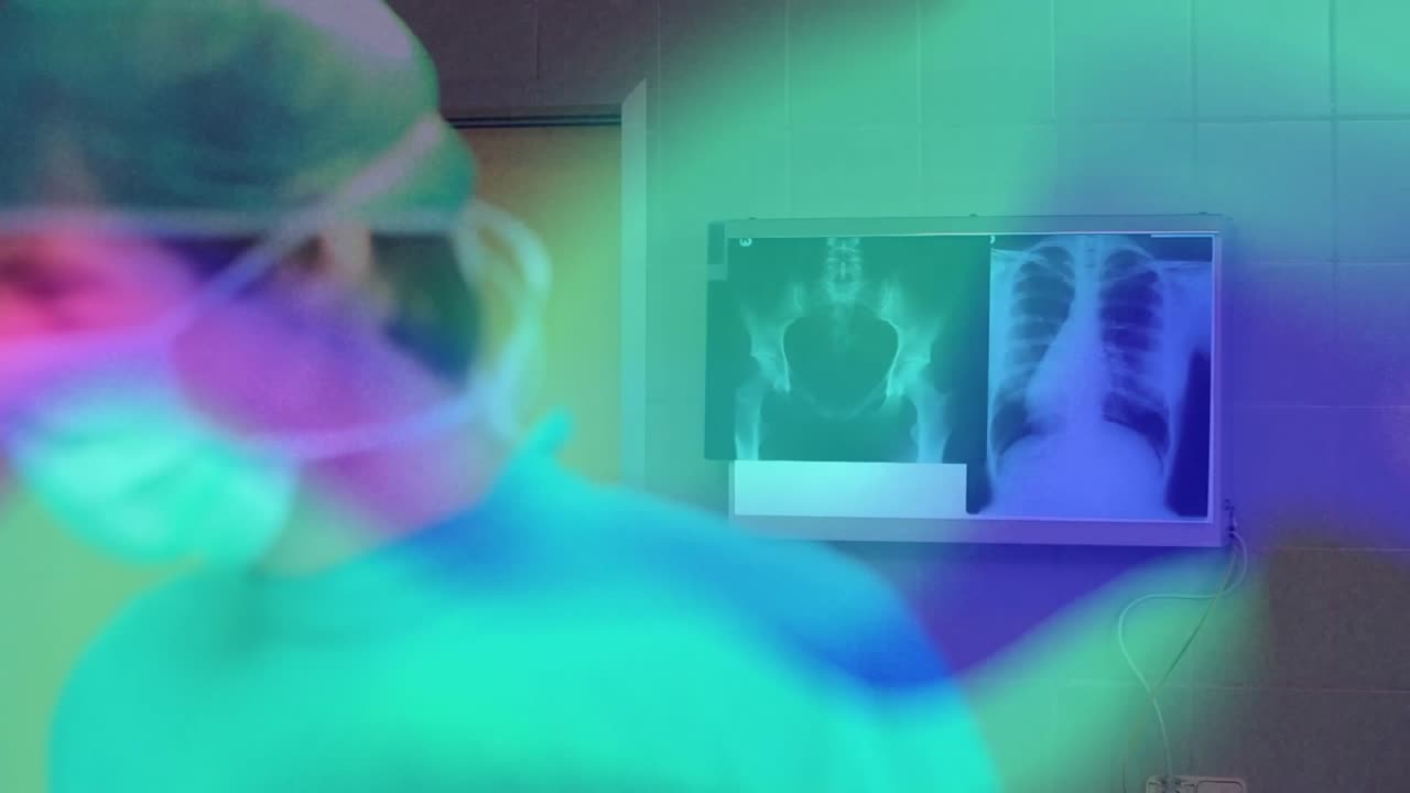 Equipe medica che esamina una radiografia, poi si avvicina al tavolo operatorio e regola la luce per la preparazione del paziente