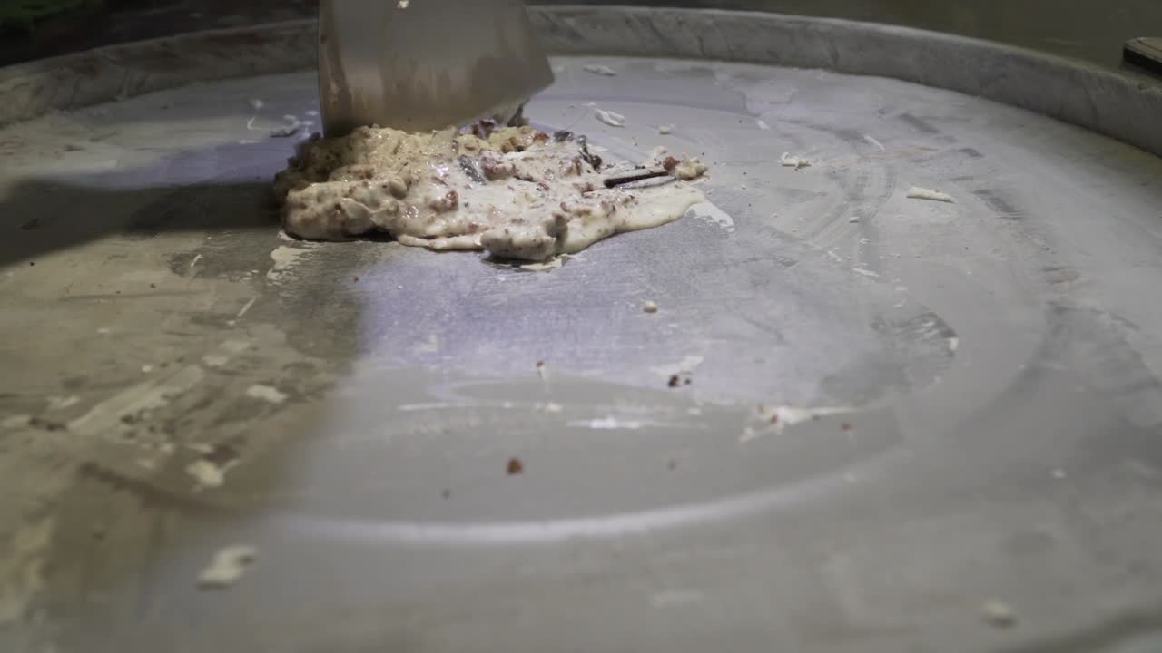 The street vendor is preparing Thai stir-fried ice cream or rolled ice cream