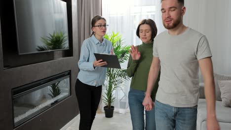 angry couple with real estate agent visiting apartment for rent or sale. buying home concept.