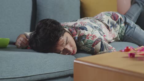 hombre durmiendo en un sofá después de una fiesta