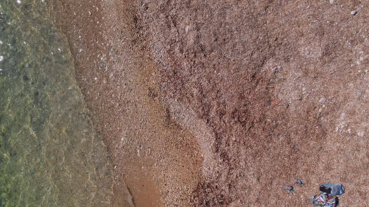 olas de una playa mediterránea de guijarros con agua turquesa