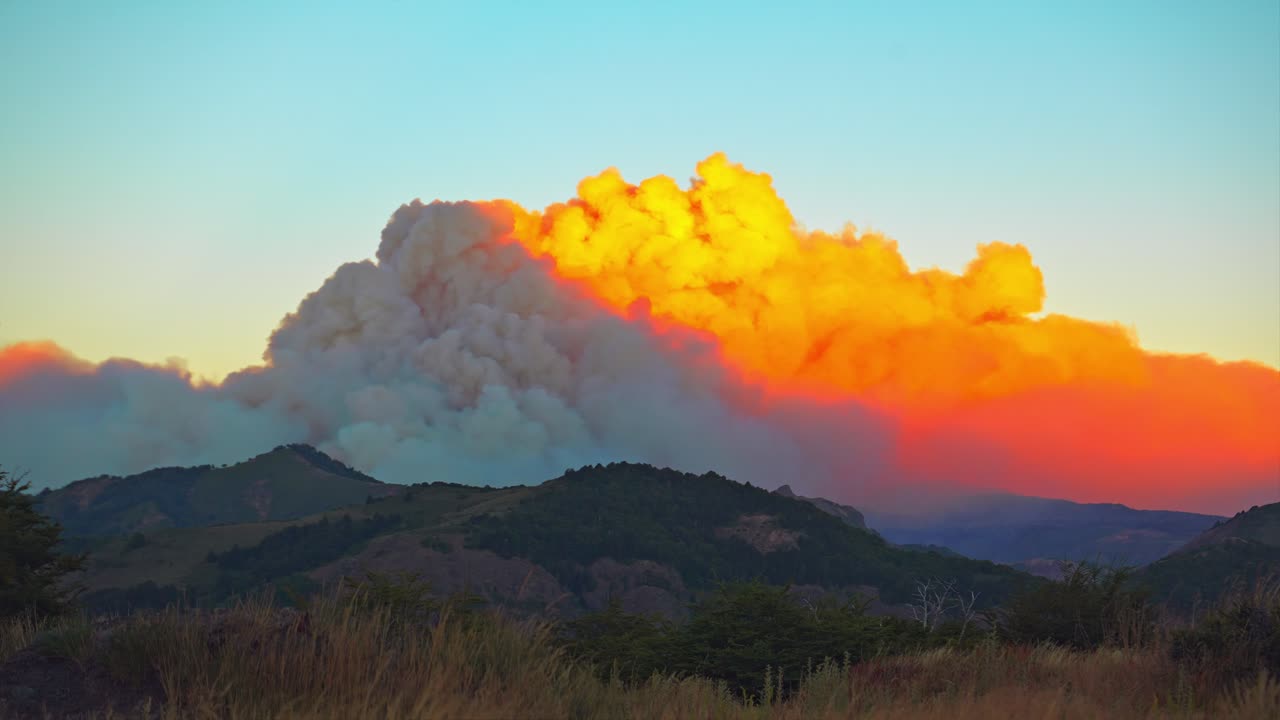 Time-Lapse of a Catastrophic Wildfire with huge Smoke Plume at Sunset over the mountain forest in Lanín National Park, Argentina