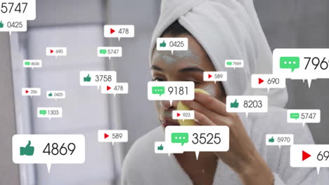 animación de barras de notificación sobre mujer biracial usando quitar crema de máscara facial usando esponja