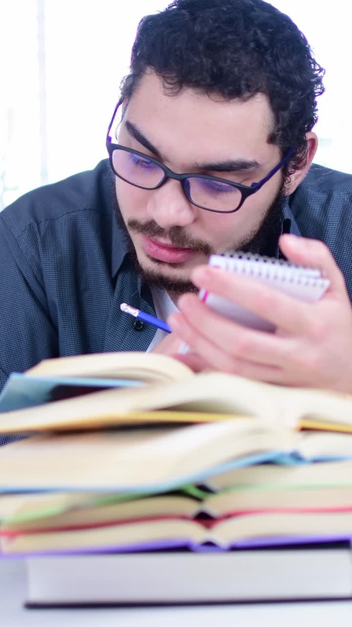 Diligent Student Taking Notes Surrounded by Books