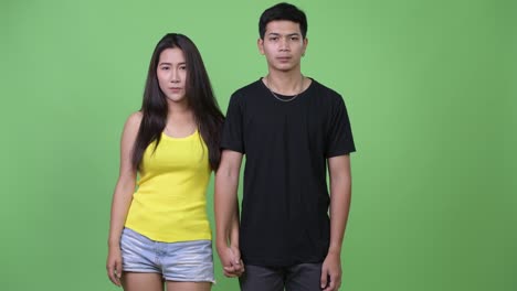 young asian couple holding hands together