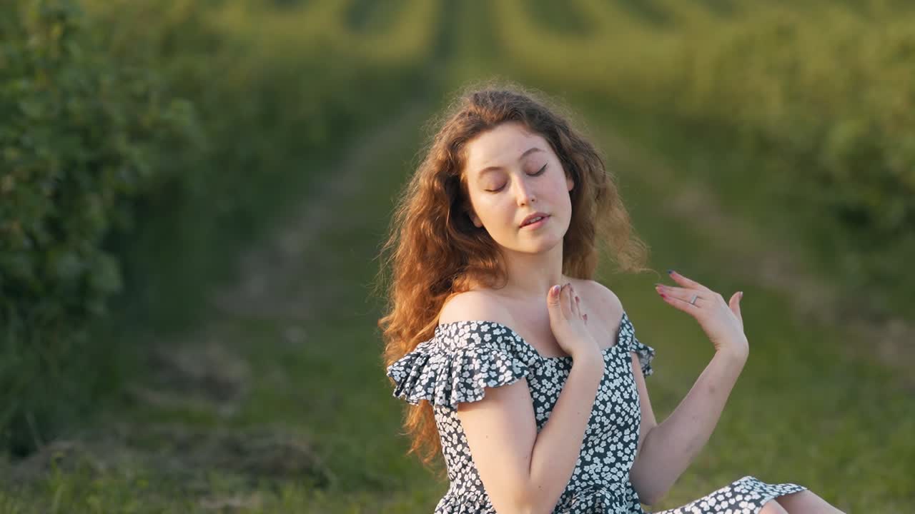 retrato de mujer pelirroja aplicando crema en la piel en el fondo del campo