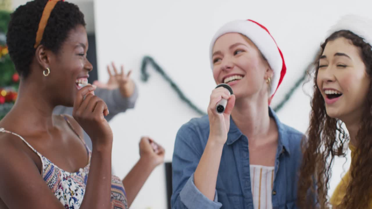un grupo feliz de amigos diversos cantando karaoke en una fiesta de navidad