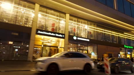 night street view in berlin, captured from inside a car. illuminated modern building, busy pedestrians, and vibrant city life. urban nightscapes and city exploration