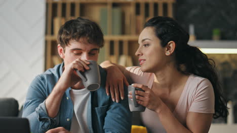 calm family relaxing home sitting on couch living room with coffee cup close up.