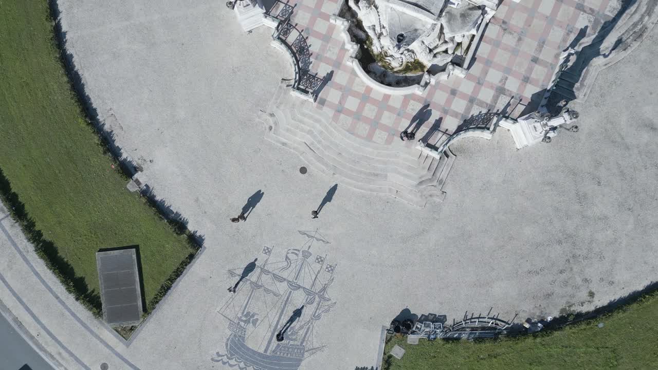 관광객들은 타일 바닥 위를 걸으면서 리스본에서 인기 있는 명소인 유서 깊은 캐러벨과 마르케 드 퐁발 동상에 경탄합니다.