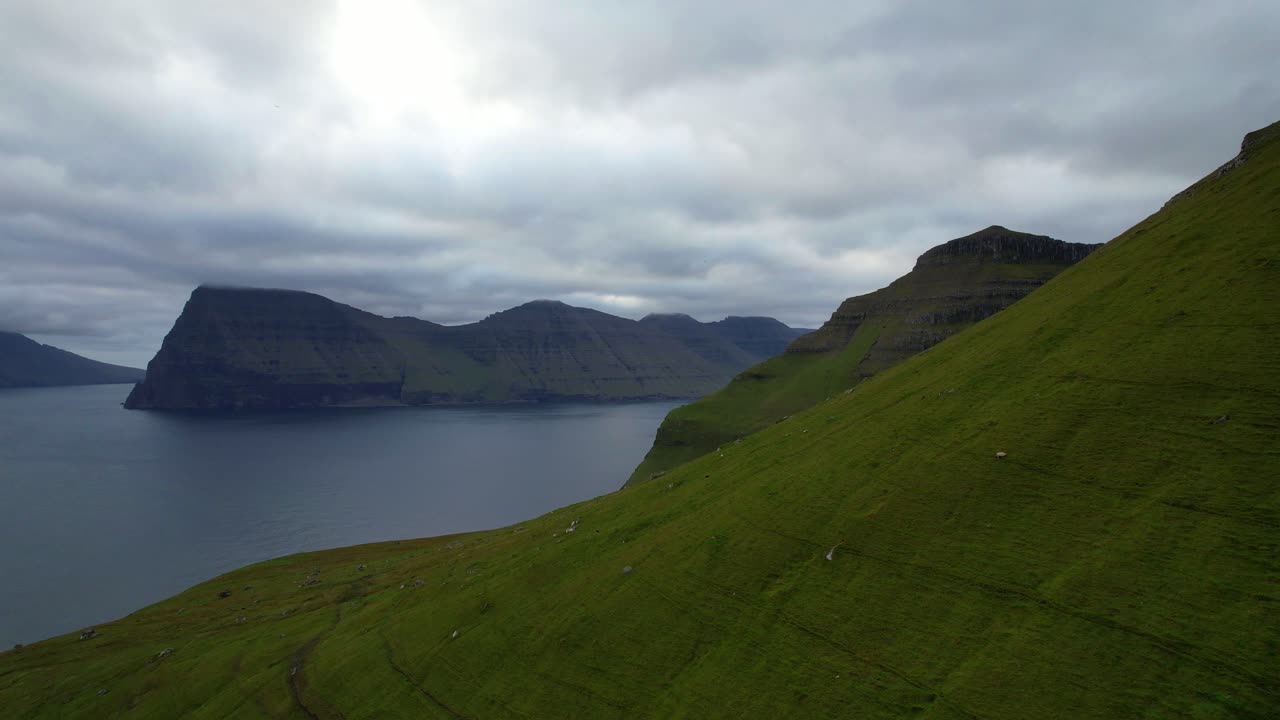 푸른 산 섬을 구름 아래에서 보여주는 무디 페로 제도 위의 공중 오른쪽 판