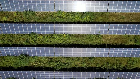 Top-view-moving-left-to-right-over-countryside-and-solar-farm-with-photovoltaics