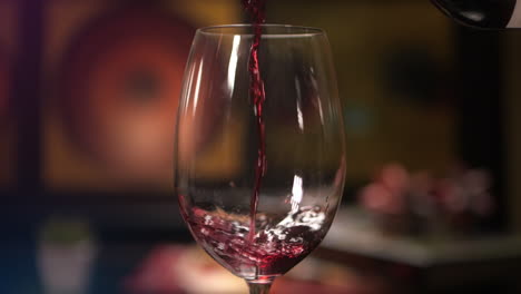 vino tinto en cámara lenta vertiendo en una copa de vino