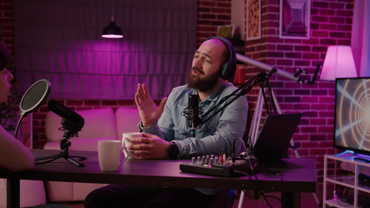 Online radio station host interviewing guest in late night talkshow recording podcast using professional microphone