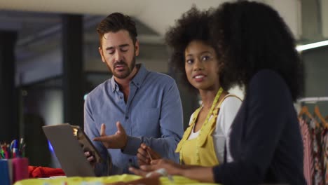 Mixed-race-colleagues-sitting-in-office-and-discussing-work-over-laptop