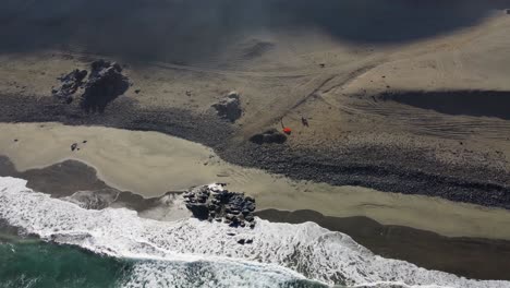 Motorradcamper-Mit-Orangefarbenem-Zelt-Genießt-Einsamkeit-An-Abgelegenem-Sandstrand