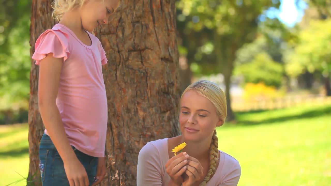 Bambina che offre un fiore a sua madre