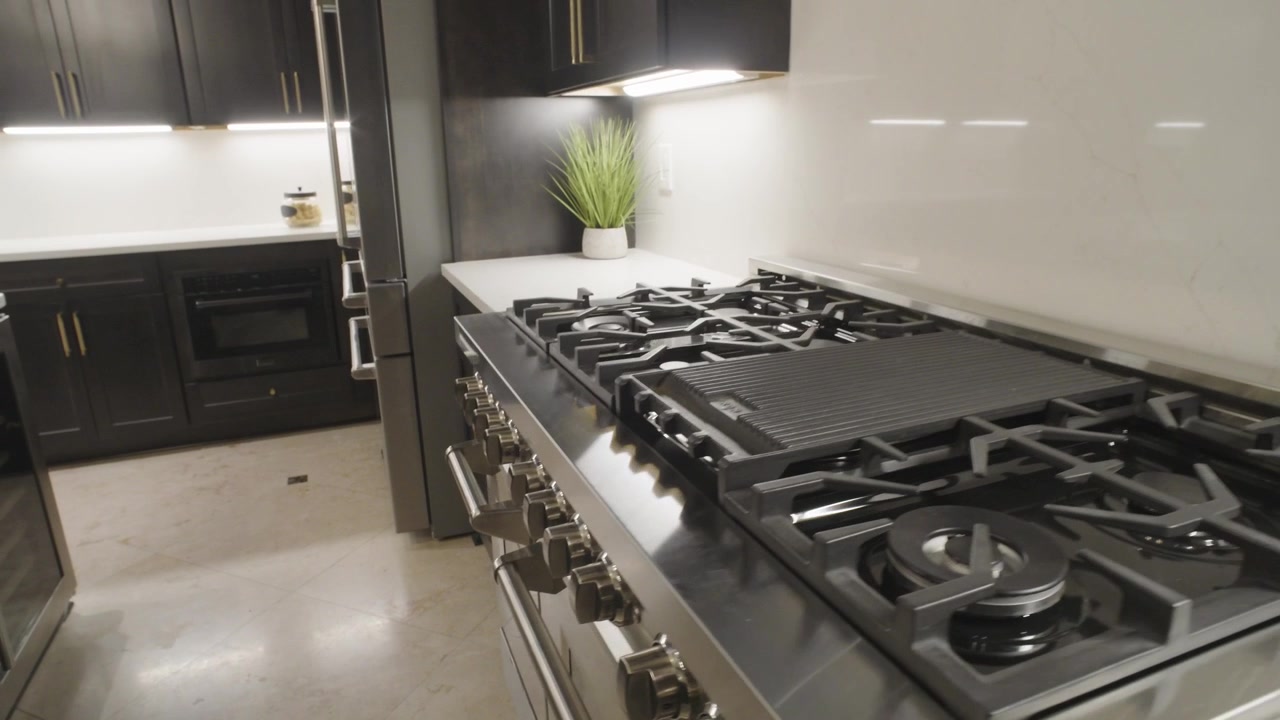 Ripresa con gimbal 4K che segue un'enorme ed elegante cucina a gas con forno.
