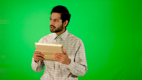 guy-using-mobile---tablet-with-green-screen-and-green-background-indian-guy-with-green-screen