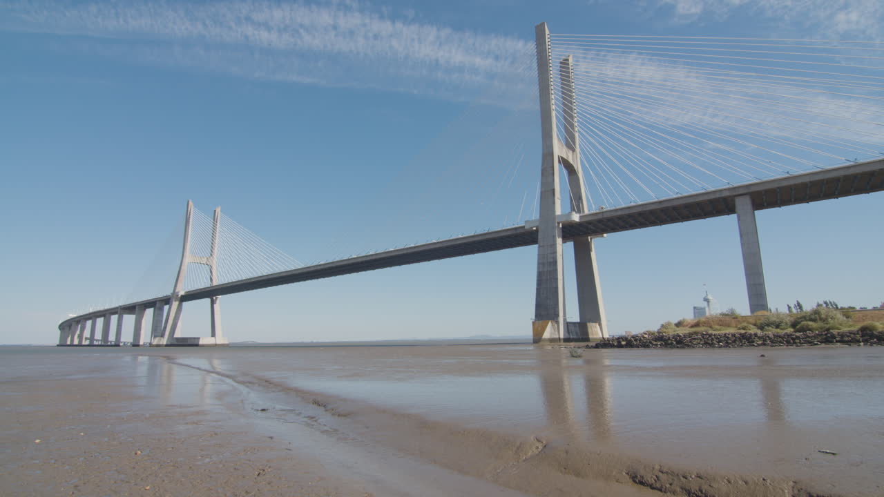 Low tide beach in Lisbon, Portugal. Vasco da gama bridge