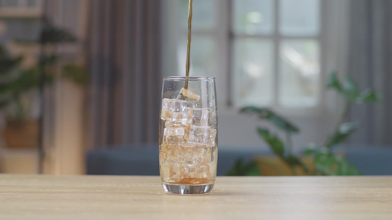 테이블 위 에 얼음 큐브 가 있는 유리잔 에 신선 한 콜라 가 여 있다