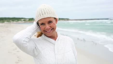 Retired-woman-standing-on-the-beach-looking-out-to-sea