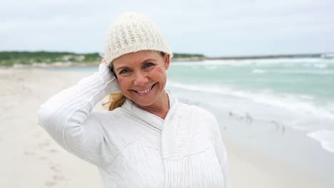 retired woman standing on the beach looking out to sea