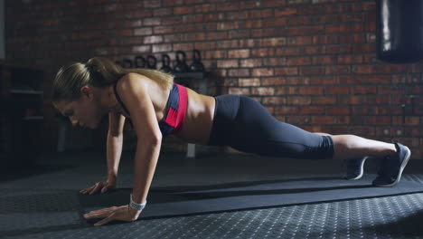 mujer haciendo un ejercicio de tabla en un gimnasio