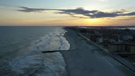 Ein-Hoher-Winkel,-Der-Während-Eines-Dunklen-Und-Goldenen-Sonnenuntergangs-über-Einen-Leeren-Strand-Geschossen-Wird