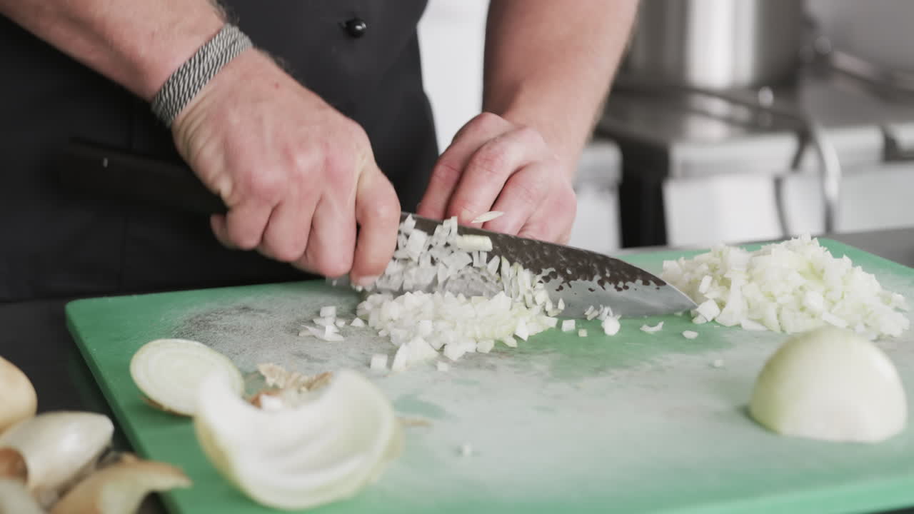 Cuoco caucasico che taglia verdure in cucina, al rallentatore