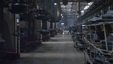 Blick-Auf-Die-Lagerung-Des-Autoreifenwerks-Mit-Arbeitersilhouette,-Die-In-Einer-Modernen-Fabrik-Läuft