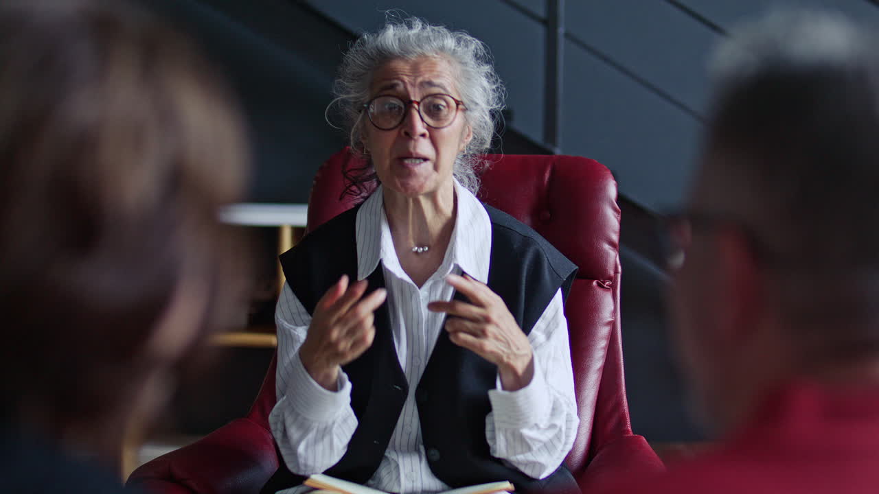 Elderly Therapist Giving Advice to Couple during Psychology Consultation