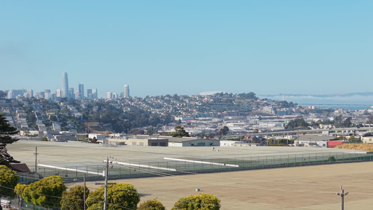 Aerial pass over Bernal Heights reveals a hillside neighborhood with eclectic homes and clear city views.