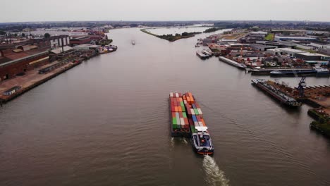 bird's eye view of two freight barge transporting intermodal container by the oude maas river