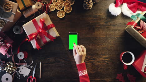 Top-view-woman-hands-using-touchscreen-smartphone-tablet-hand-gestures-green-screen-table-from-above---Red-Epic-Dragon