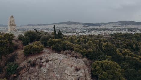 Vista,-De,-Un,-Hombre-Estar-De-Pie,-En,-El,-Pie,-De,-Acrópolis,-Colina,-En,-Atenas,-Grecia,--,-Aéreo,-órbita