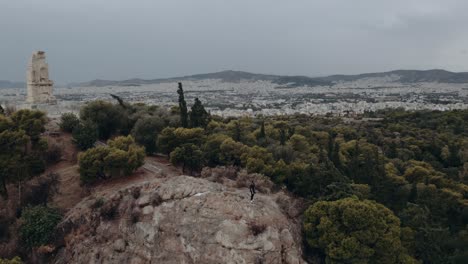 vista, de, un, hombre estar de pie, en, el, pie, de, acrópolis, colina, en, atenas, grecia, -, aéreo, órbita