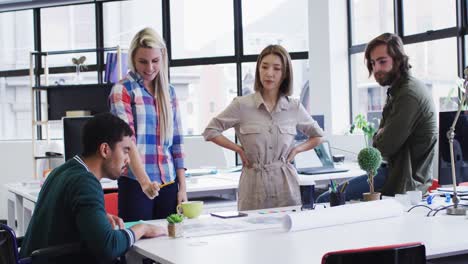 diversos colegas de oficina con máscaras faciales discutiendo sobre el plan de diseño en una oficina moderna