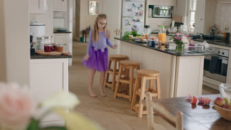 happy ballerina girl dancing in kitchen wearing purple tutu having fun performing funny dance moves enjoying weekend celebration at home